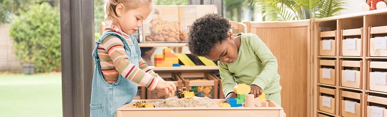 Two children playing at an Activity top shelf