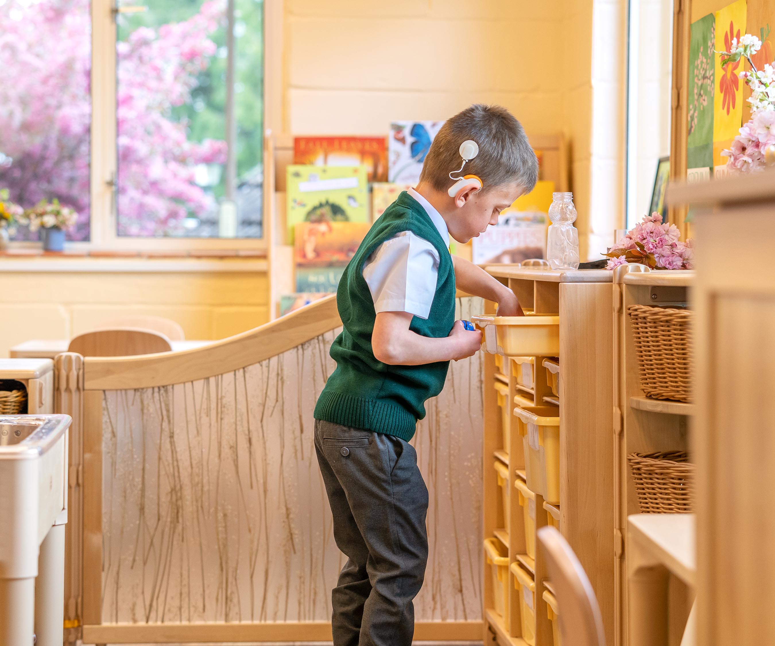 A reception aged boy pulling out a tray.