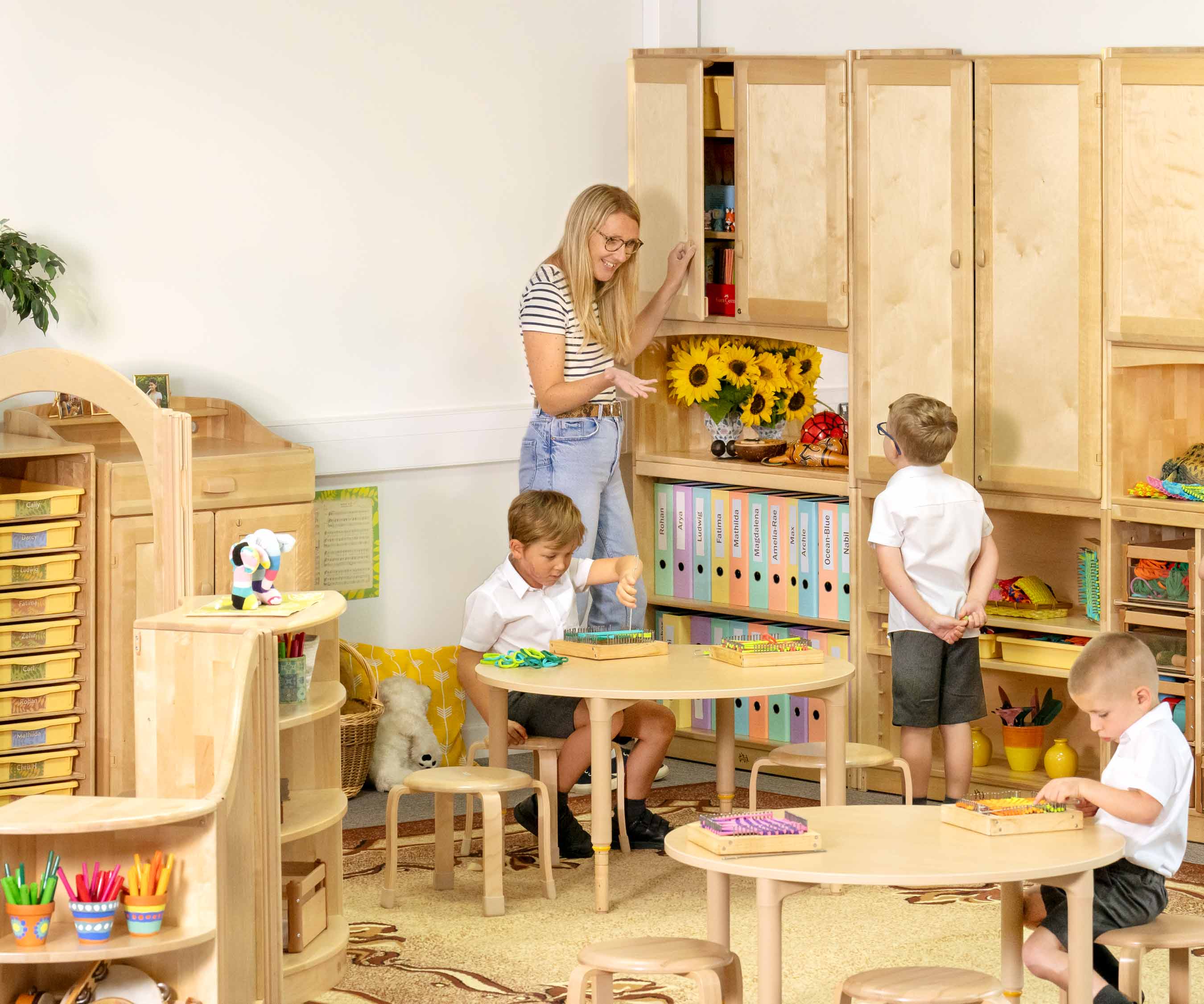 Teacher and children with wall cupboards