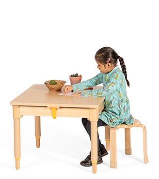 A reception aged girl doing leaf rubbing on an Activity tray-table