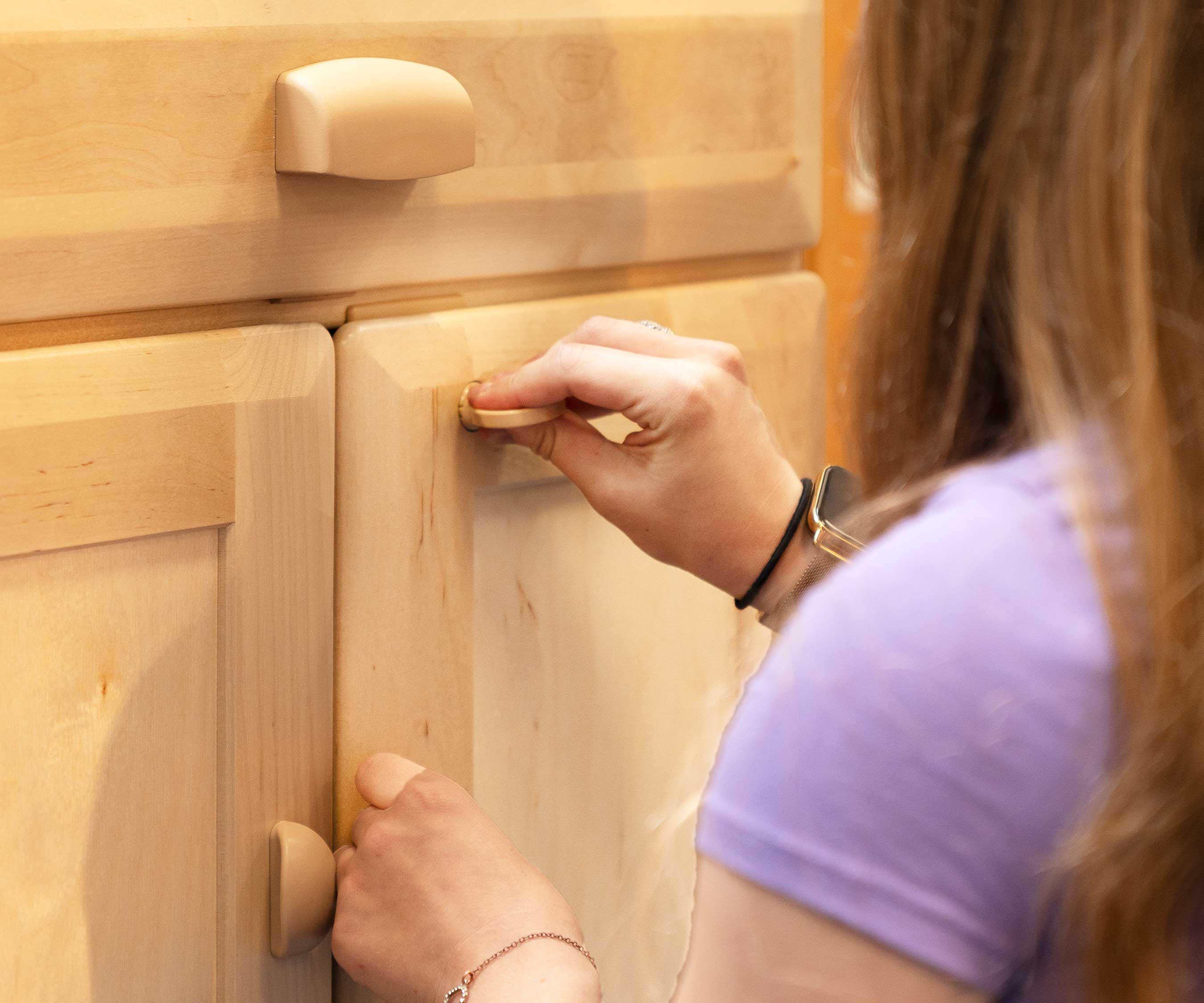 A teacher opens the doors of the teacher standing desk using the plastic key provided
