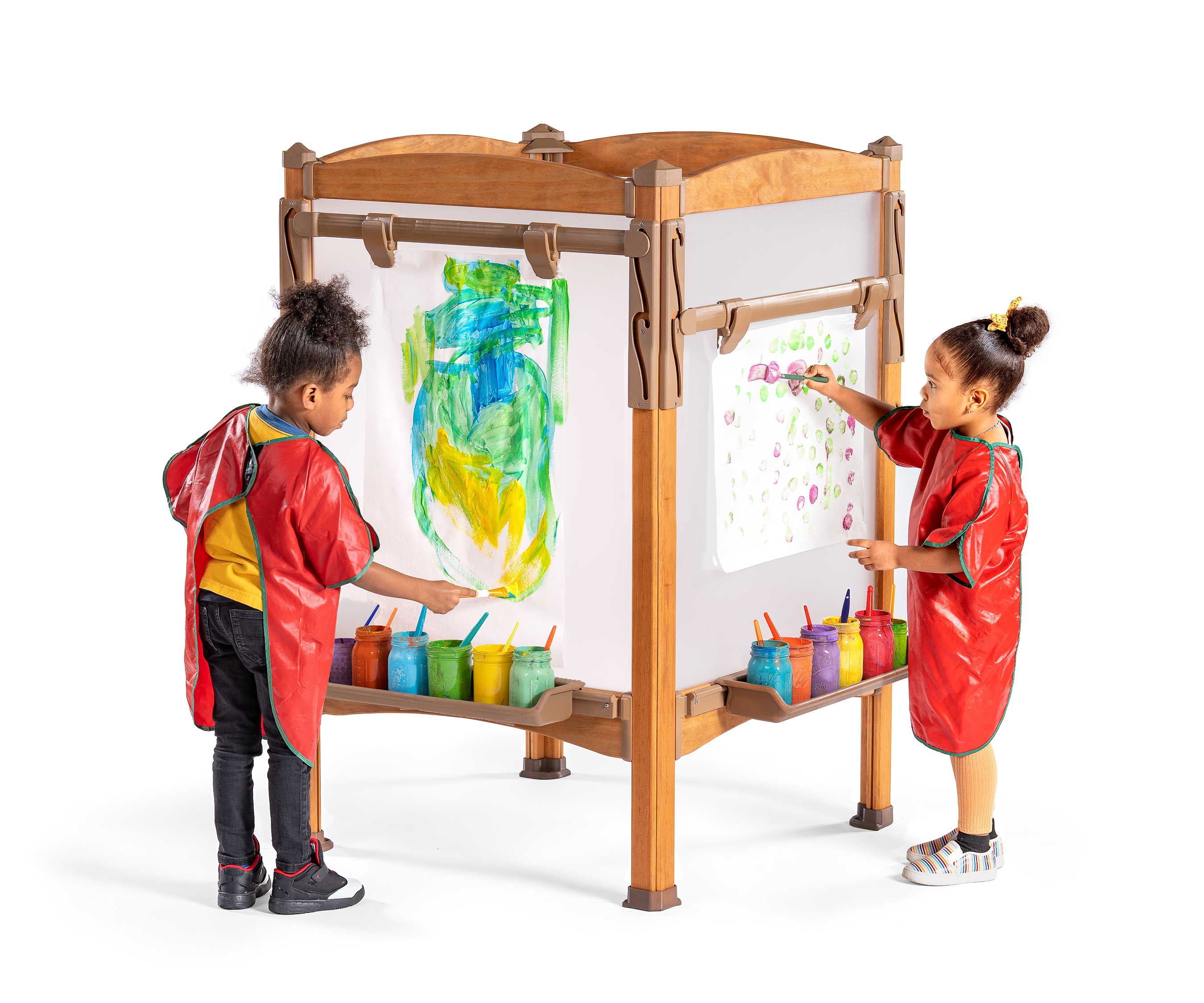 An older and younger child painting pictures at an outdoor easel that can be adjusted to age appropriate heights.