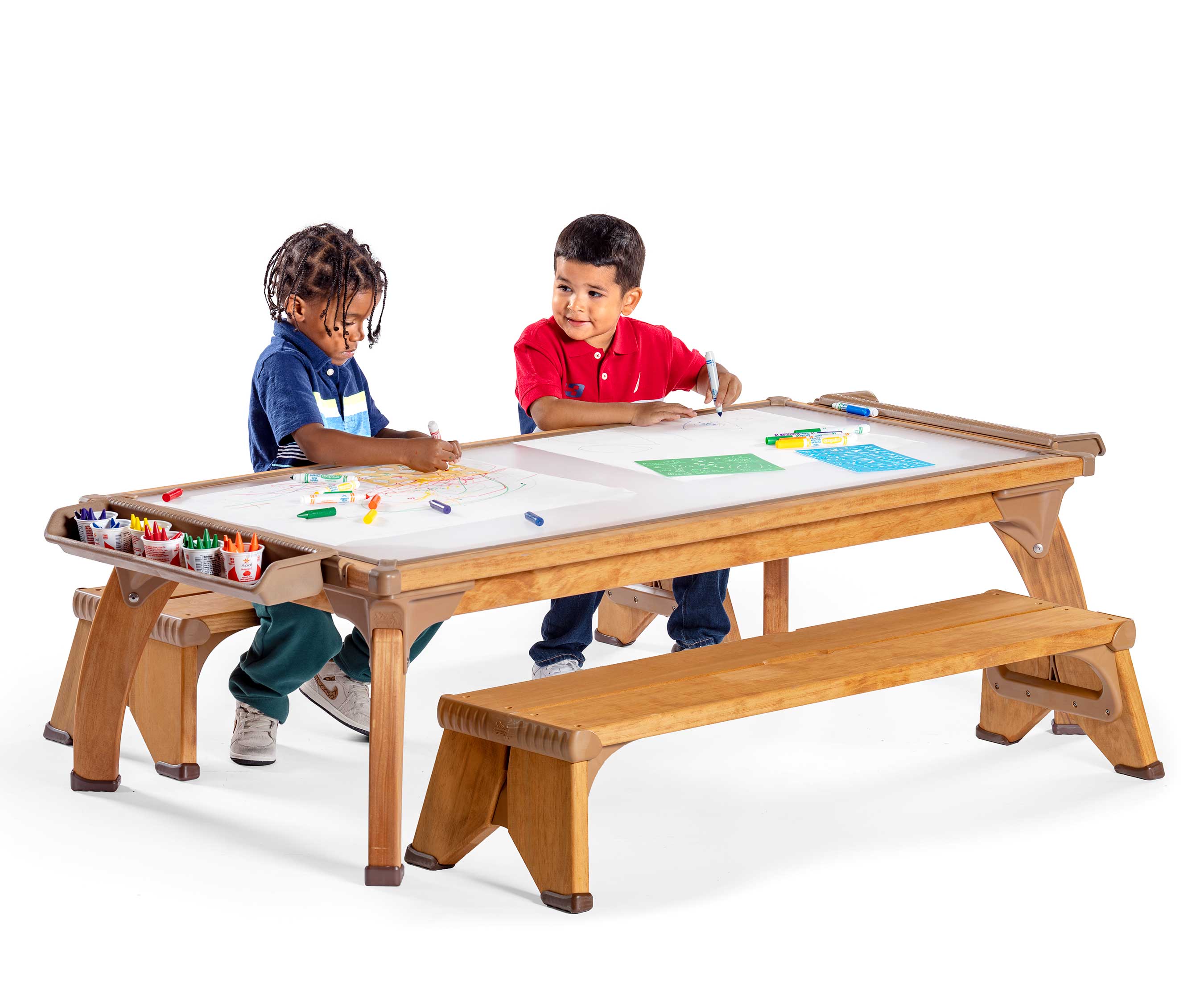 Two preschool age boys drawing together at an outdoor art table.
