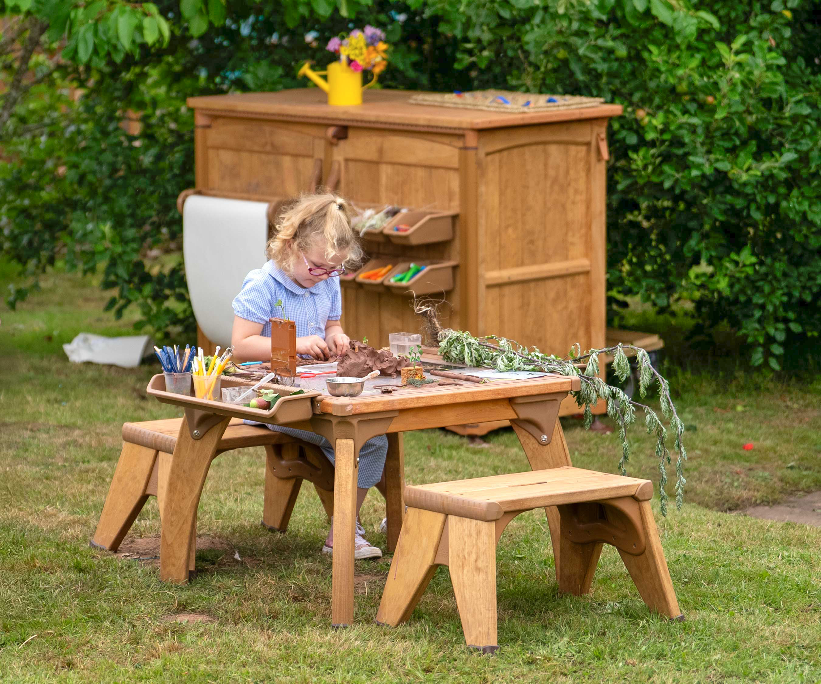 A primary school outdoor setting with a child engrossed in science and exploration at a project table.