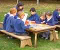 Primary school class studying science outdoors at an Outlast table.