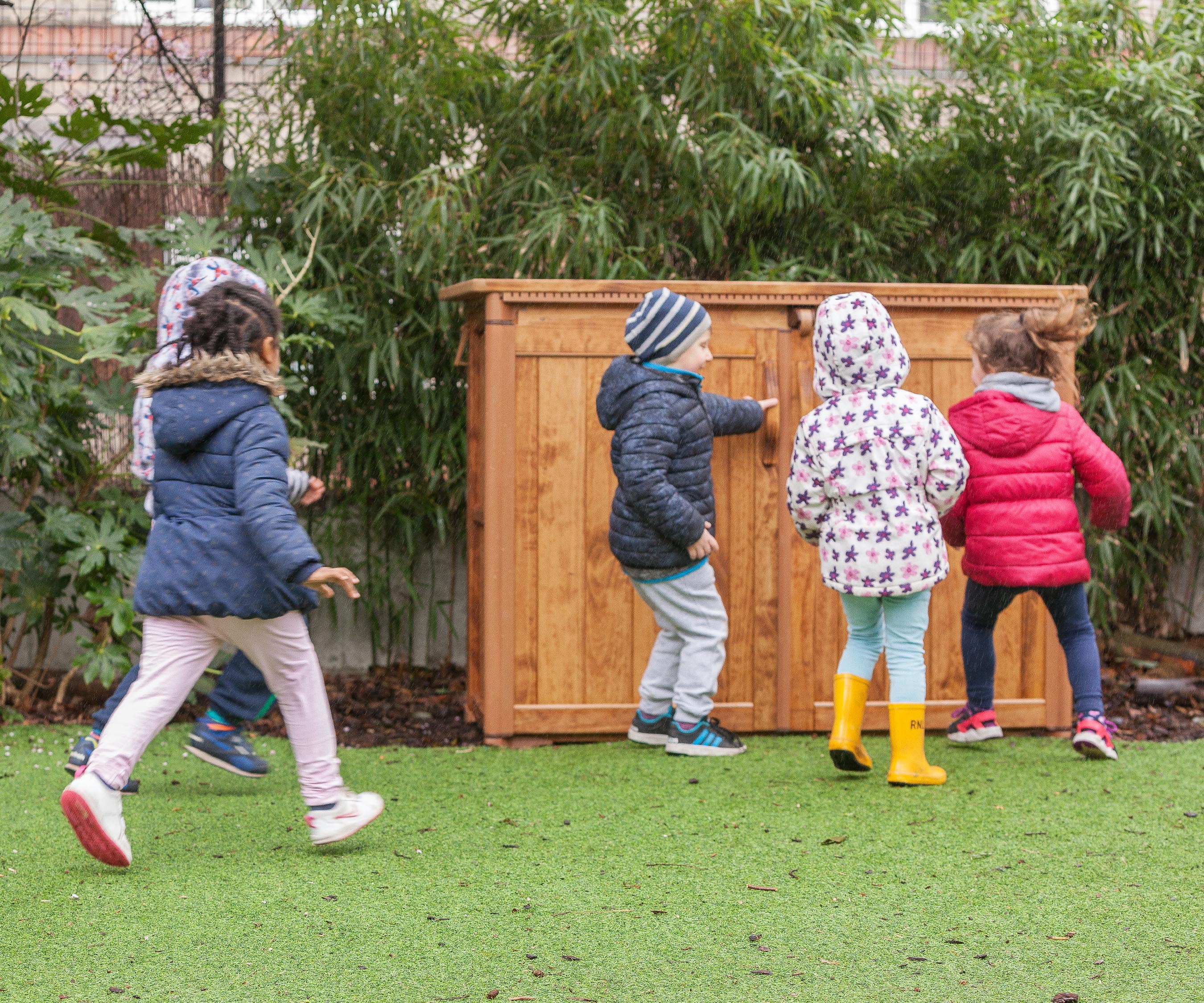 Four reception aged children running to open an Outlast storage unit.