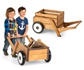 A crate in an Outlast wheelbarrow and two boys pushing a two wheeled children’s wooden wheelbarrow