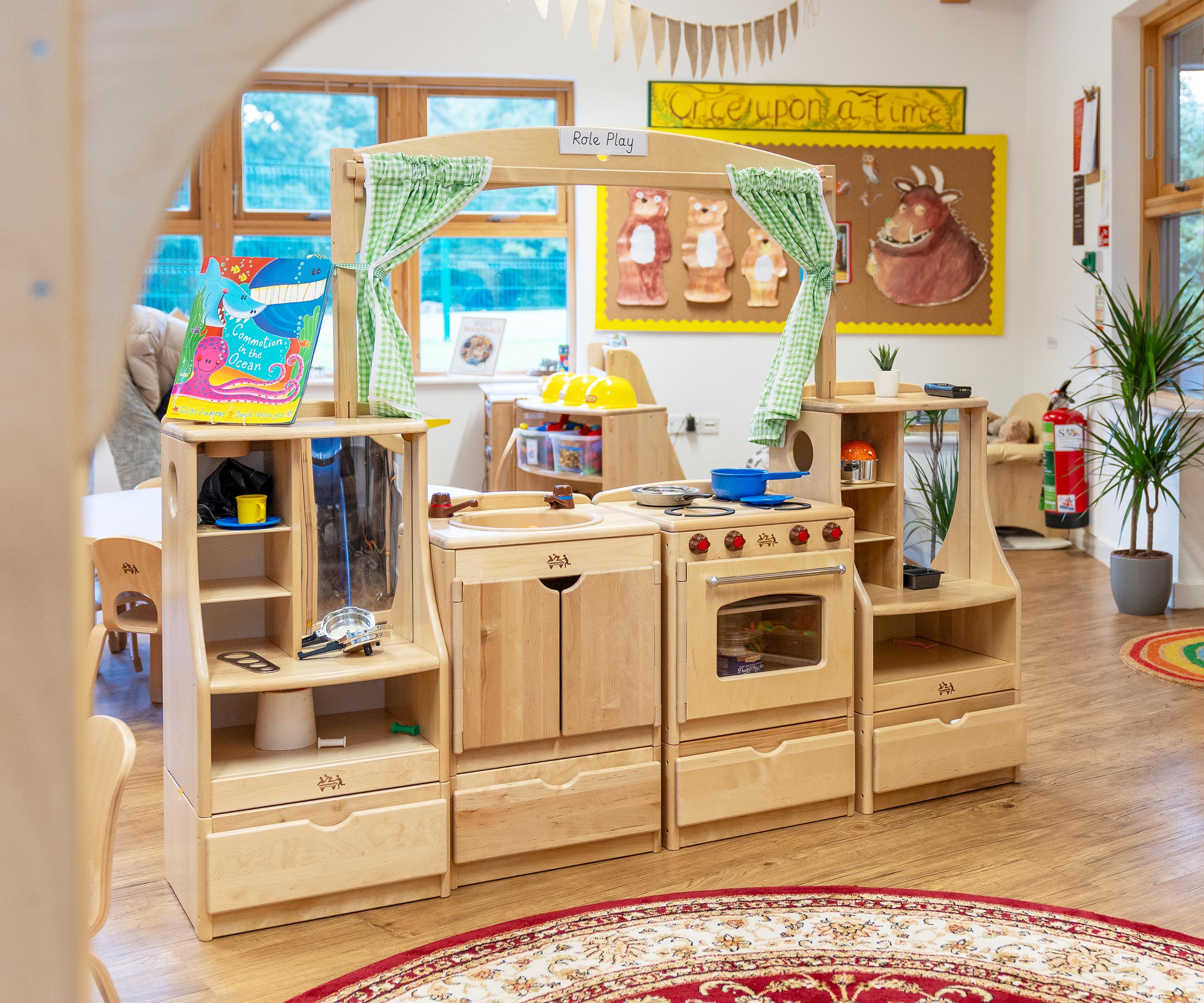 Solid wood play kitchen with sink, stove, and cabinets