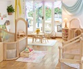 A Reggio-inspired toddler room set up with solid wood furniture and beautiful, calming colours