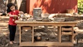 A child plays at a mud kitchen counter