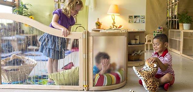 Three children playing in a classroom.